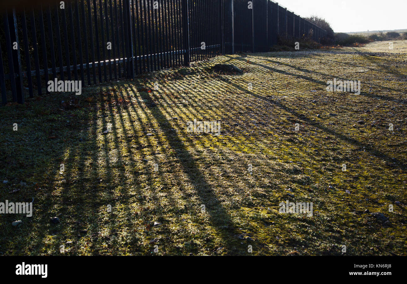 Landschaft schoss der Schatten von einem Zaun über unebenen Boden Stockfoto