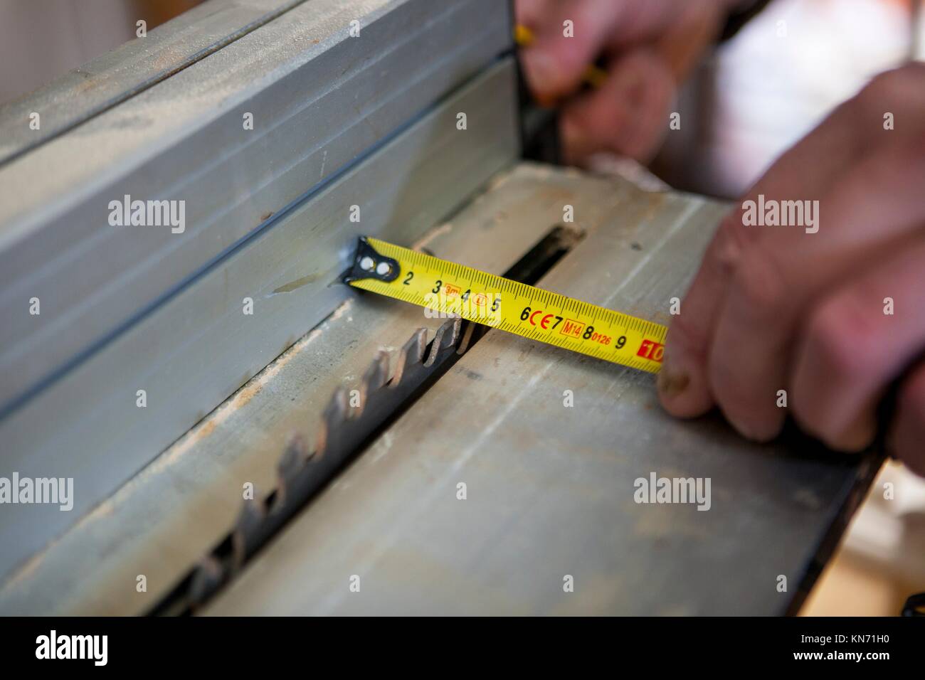 Tischler arbeiten mit Türpfosten mit elektrischen Kreissäge. Er ist die Messung der Bereich schneiden. Stockfoto
