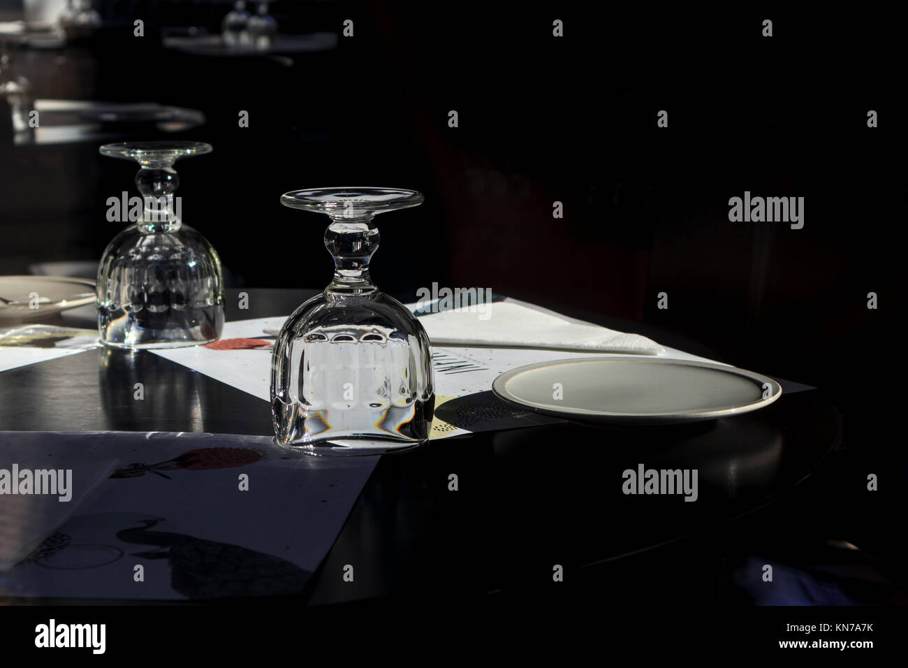 Ort Einstellung mit umgedrehten Wasser Glas und Menü auf einem dunklen Hintergrund Stockfoto