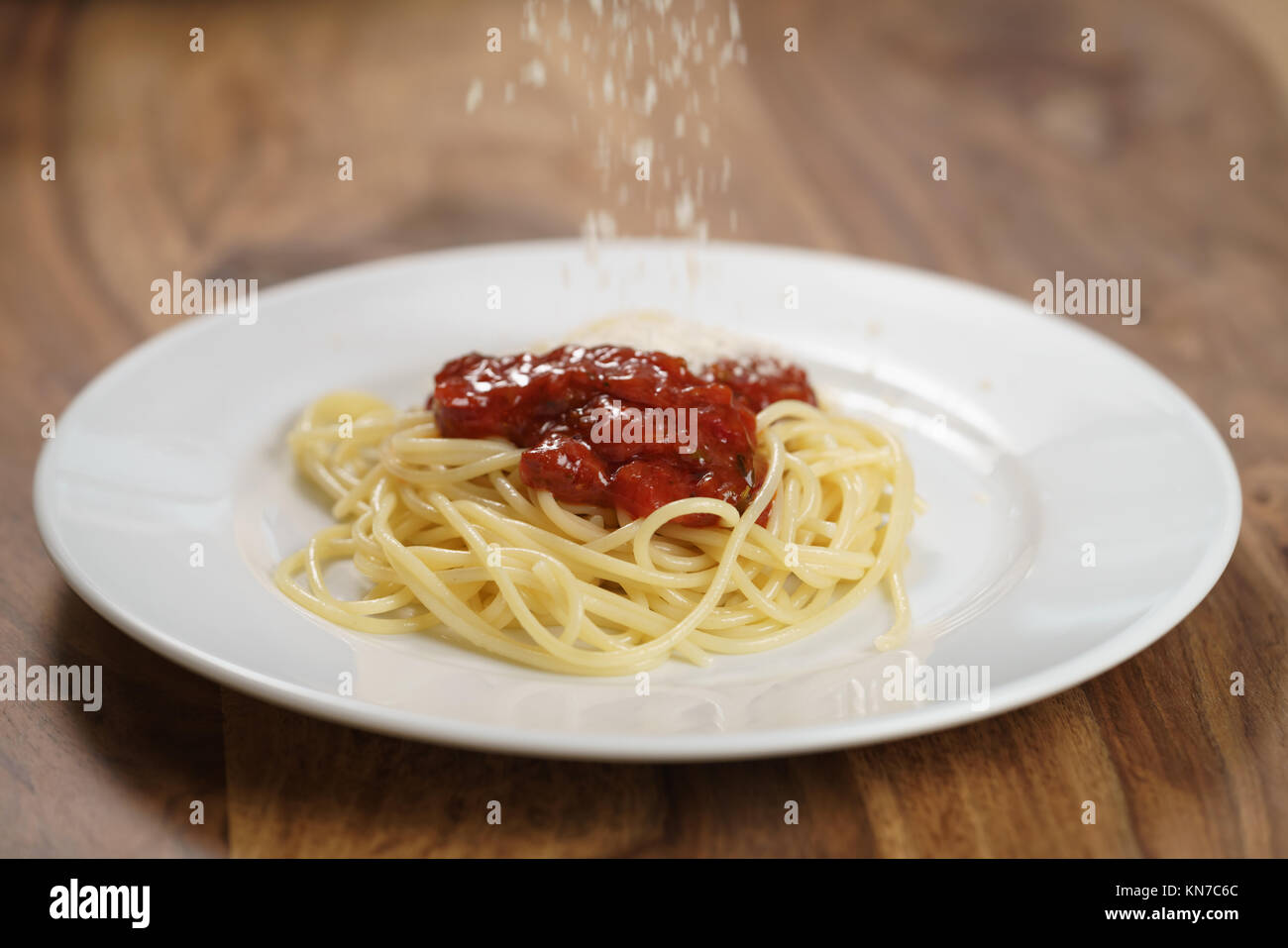 Geriebenen Parmesan auf spaghetti bolognese hinzufügen, flacher Fokus Stockfoto