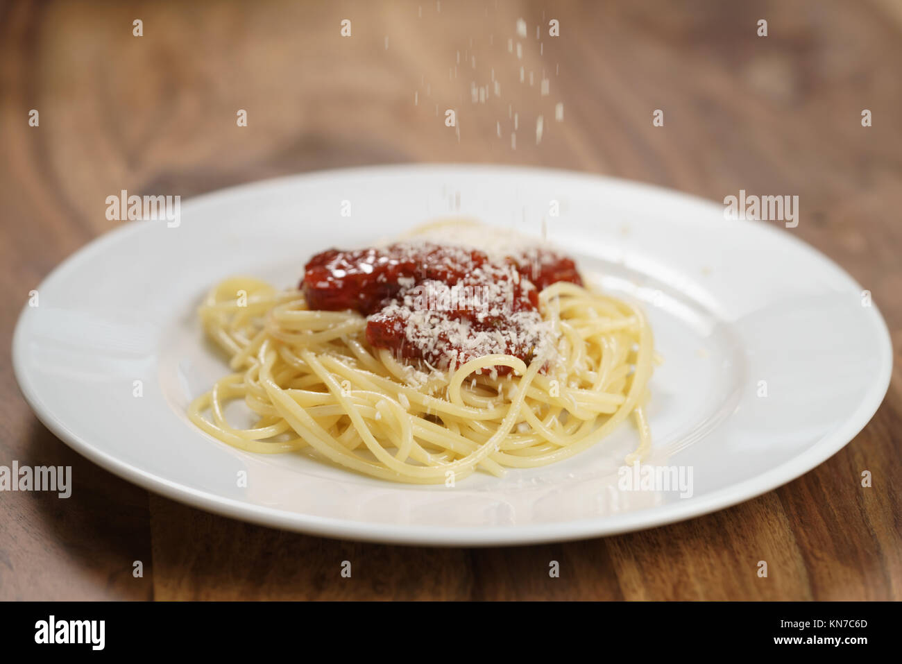 Geriebenen Parmesan auf spaghetti bolognese hinzufügen, flacher Fokus Stockfoto