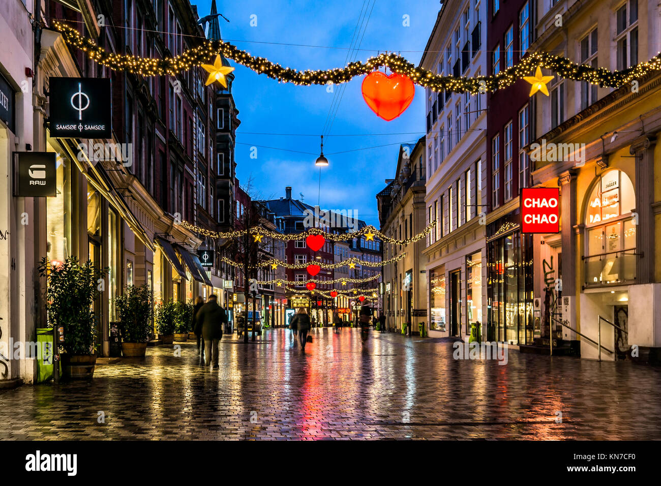 Weihnachtseinkaufsstraße in Kopenhagen mit einigen Leuten, die nachts spazieren gehen, geschmückt mit rot leuchtenden Herzen, Kobmagergade, Dänemark, 5. Dezember 2013 Stockfoto