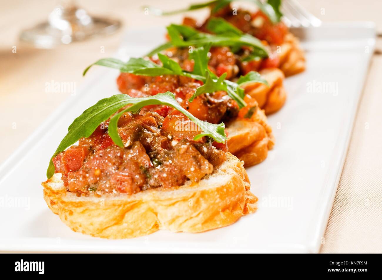 Frische tipycal italienische Bruschetta mit Tomaten und Rucola an der Spitze. Stockfoto