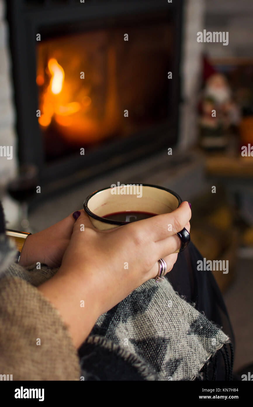 Frau trinkt Glühwein am Kamin, winter Lifestyle Stockfoto