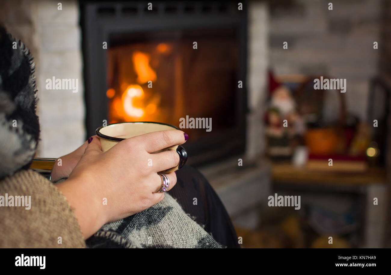 Frau trinkt Glühwein am Kamin, winter Lifestyle Stockfoto