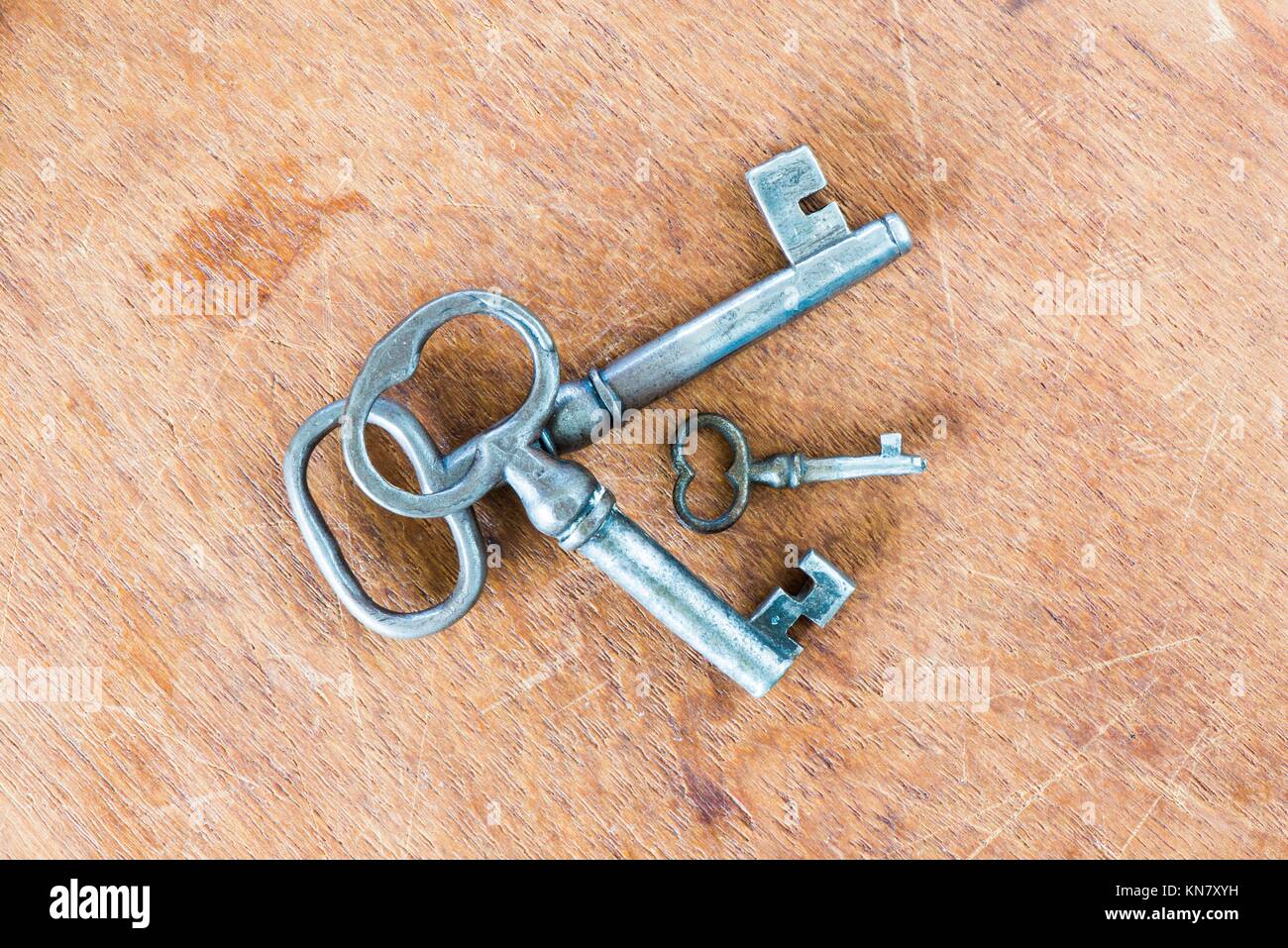 Verschiedene Schlüssel in alten Vintage Retro Stil auf Holz- Oberfläche.  Satz von drei von klein bis groß. Symbol für Sicherheit, Vielfalt und  Differenz Stockfotografie - Alamy