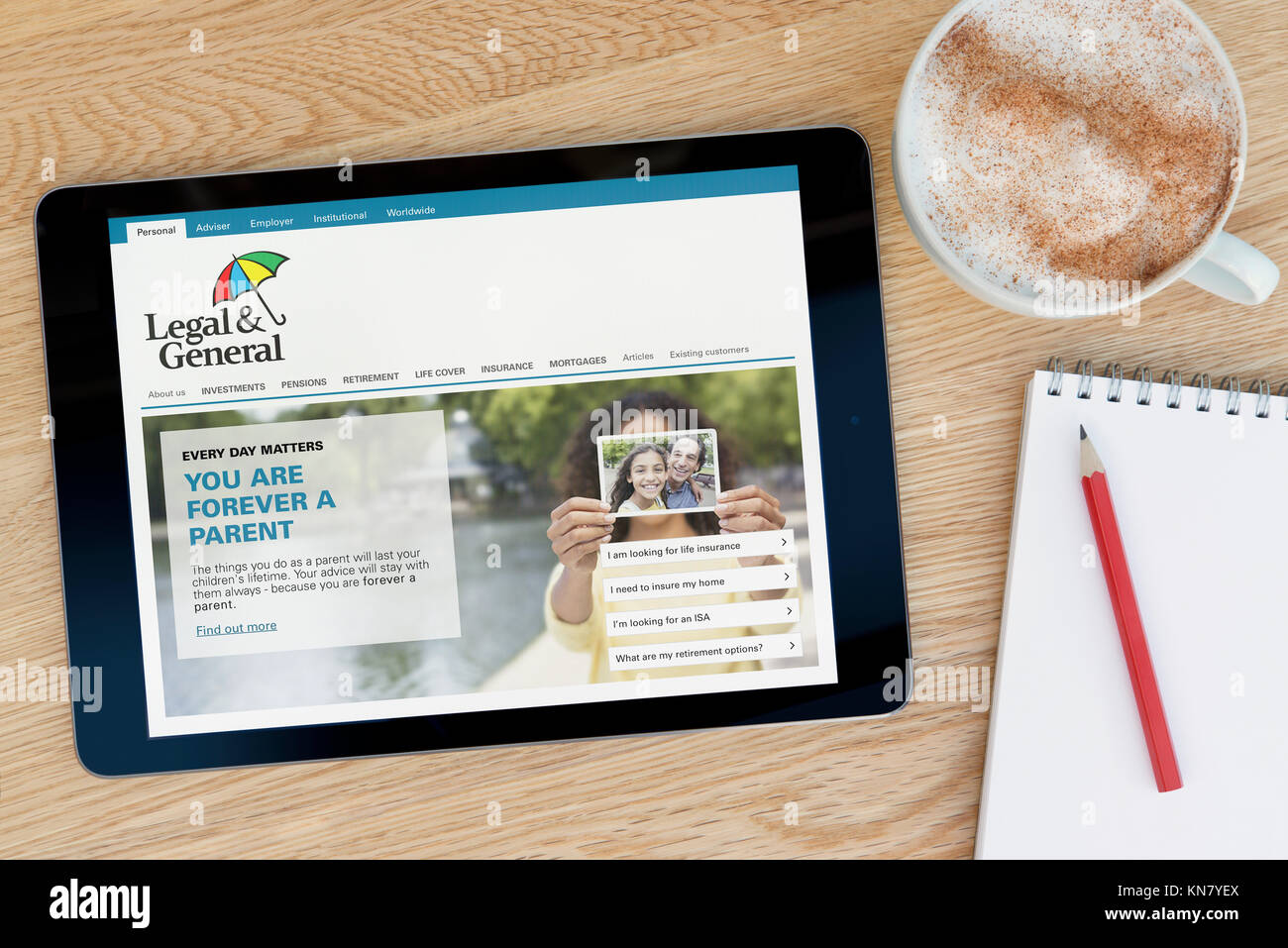 Die Legal & General Website auf einem iPad Tablet Gerät, das auf einem Tisch liegt neben einem Notizblock und Bleistift und eine Tasse Kaffee (nur redaktionell) Stockfoto