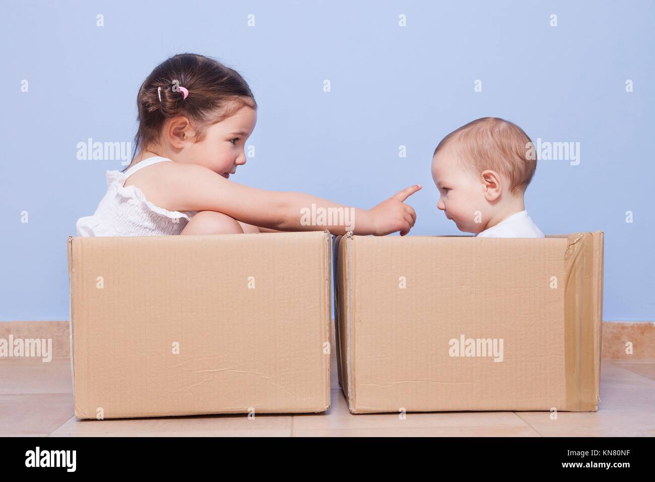 Baby und Kleinkind Bruder Schwester spielen in Kartons. Stockfoto
