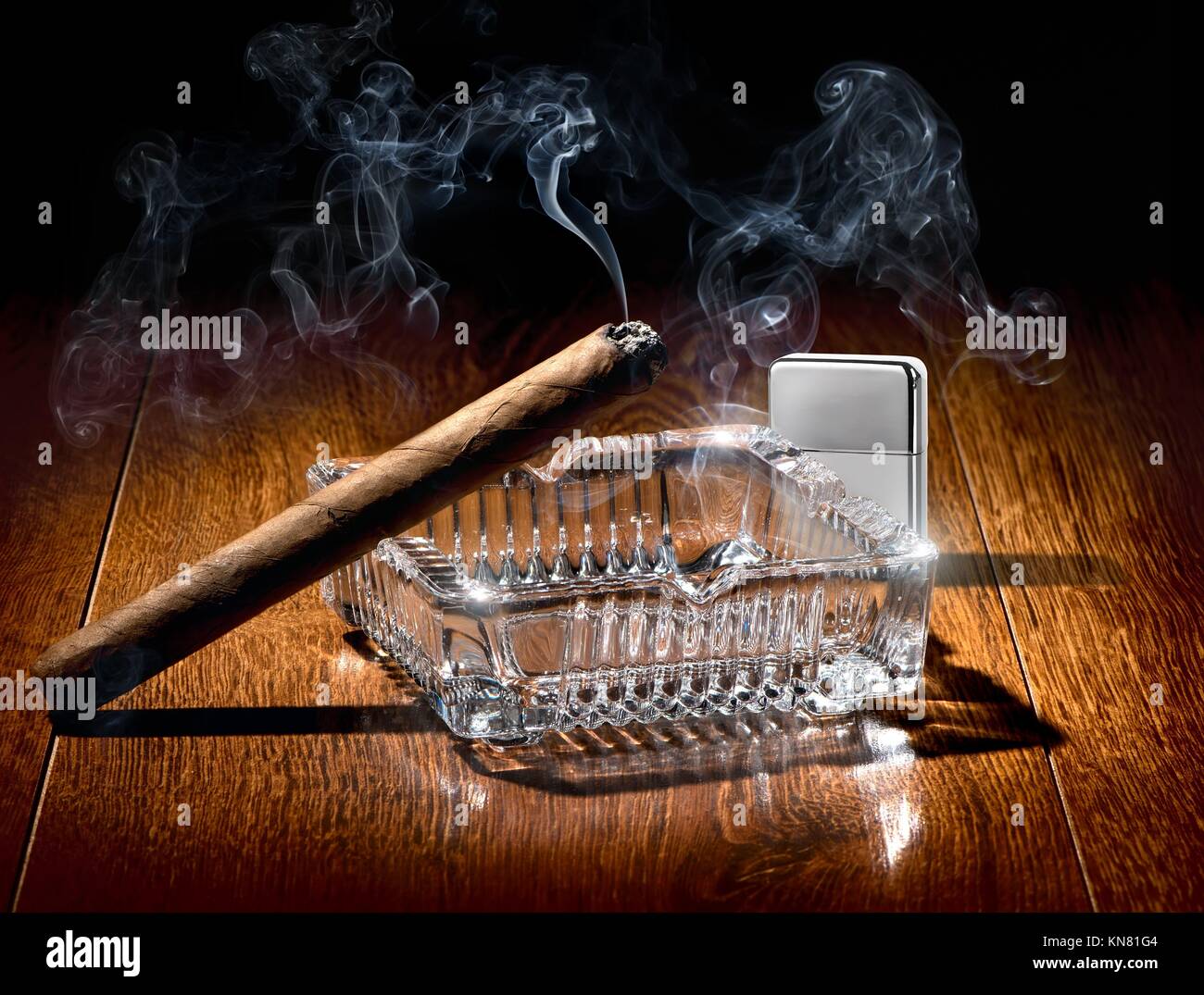 Zigarre auf Aschenbecher und Zigarettenanzünder Silber auf einer hölzernen Tisch. Stockfoto