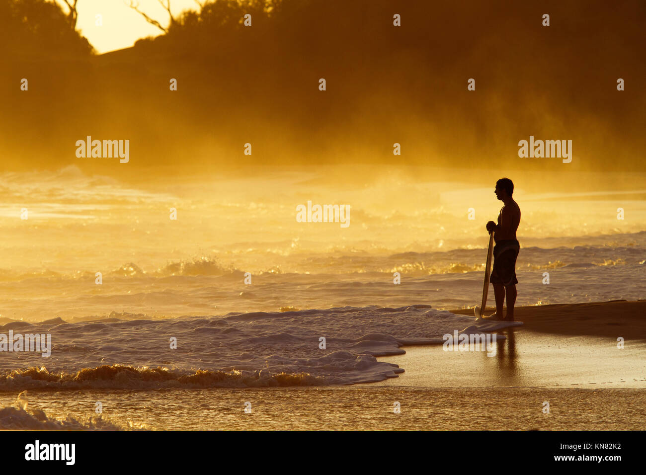 Skimboarder bei Sonnenuntergang in Makena, Maui, Hawaii. Stockfoto