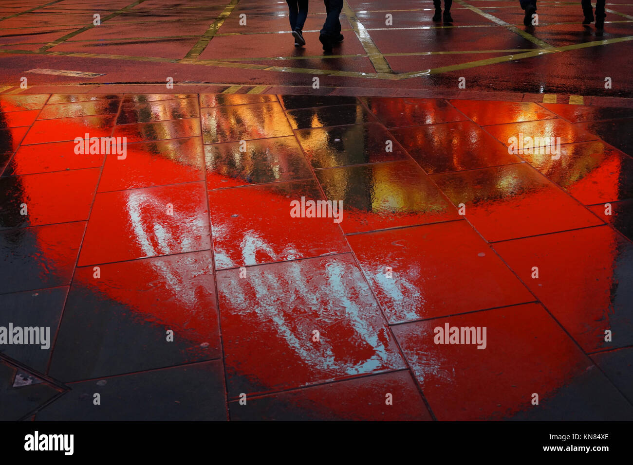 Eine Coca Cola Werbung ist in der Nacht auf nasser Fahrbahn am Piccadilly Circus, London wider. Stockfoto