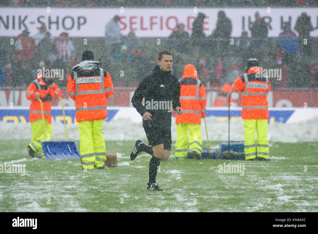 Koeln, Deutschland. 10 Dez, 2017 Schiedsrichter Dr. Robert KAMPKA laeuft ueber den Pitch, waehrend Helfer Schnee raeumen, r umen, Fussball 1. Bundesliga, 15. Spieltag, 1.FC Köln (K) - SC Freiburg (FR) 3:4, am 10.12.2017 in Köln/Deutschland. | Verwendung der weltweiten Kredit: dpa/Alamy leben Nachrichten Stockfoto