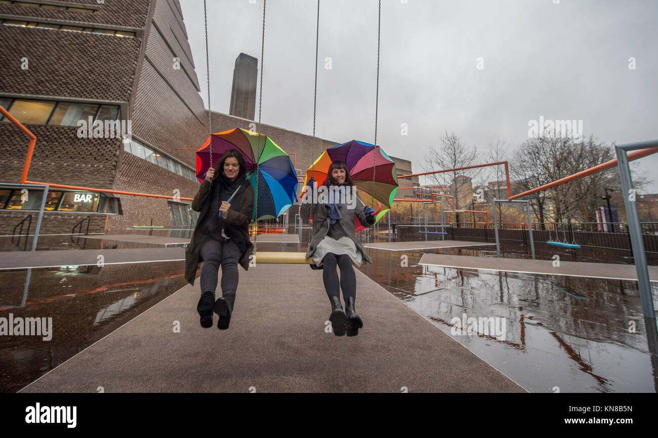 Tate Modern, London, UK. 11. Dezember, 2017. Elf schaukeln müssen außerhalb der Galerie Blavatnik Gebäude installiert wurde, als Teil einer groß angelegten interaktive Installation von Dänischen kollektiv SUPERFLEX. Eins, Zwei, Drei! Ist die erste Hyundai Kommission über die Turbine Hall zu erweitern und in die Landschaft draußen. Die großen Installation verfügt über elf 3 Sitz schwingt vor dem Hintergrund der legendären Tate Modern Gebäude mit Mitgliedern der lokalen Gemeinschaft genießen die Schaukeln für die erste Zeit im strömenden Regen. Credit: Malcolm Park/Alamy Leben Nachrichten. Stockfoto
