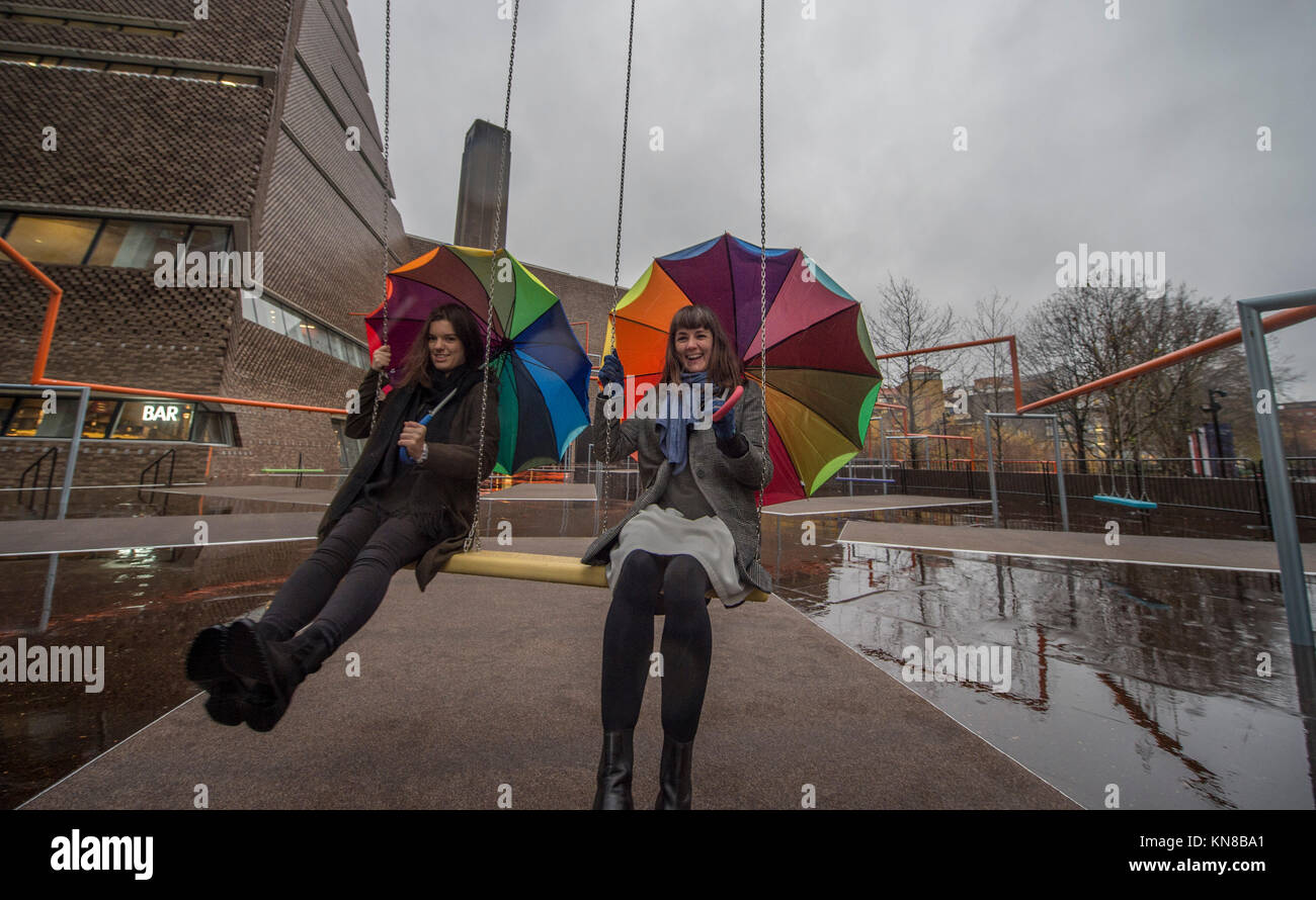Tate Modern, London, UK. 11. Dezember, 2017. Elf schaukeln müssen außerhalb der Galerie Blavatnik Gebäude installiert wurde, als Teil einer groß angelegten interaktive Installation von Dänischen kollektiv SUPERFLEX. Eins, Zwei, Drei! Ist die erste Hyundai Kommission über die Turbine Hall zu erweitern und in die Landschaft draußen. Die großen Installation verfügt über elf 3 Sitz schwingt vor dem Hintergrund der legendären Tate Modern Gebäude mit Mitgliedern der lokalen Gemeinschaft genießen die Schaukeln für die erste Zeit im strömenden Regen. Credit: Malcolm Park/Alamy Leben Nachrichten. Stockfoto
