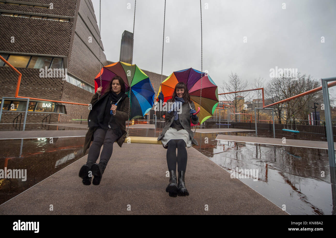 Tate Modern, London, UK. 11. Dezember, 2017. Elf schaukeln müssen außerhalb der Galerie Blavatnik Gebäude installiert wurde, als Teil einer groß angelegten interaktive Installation von Dänischen kollektiv SUPERFLEX. Eins, Zwei, Drei! Ist die erste Hyundai Kommission über die Turbine Hall zu erweitern und in die Landschaft draußen. Die großen Installation verfügt über elf 3 Sitz schwingt vor dem Hintergrund der legendären Tate Modern Gebäude mit Mitgliedern der lokalen Gemeinschaft genießen die Schaukeln für die erste Zeit im strömenden Regen. Credit: Malcolm Park/Alamy Leben Nachrichten. Stockfoto