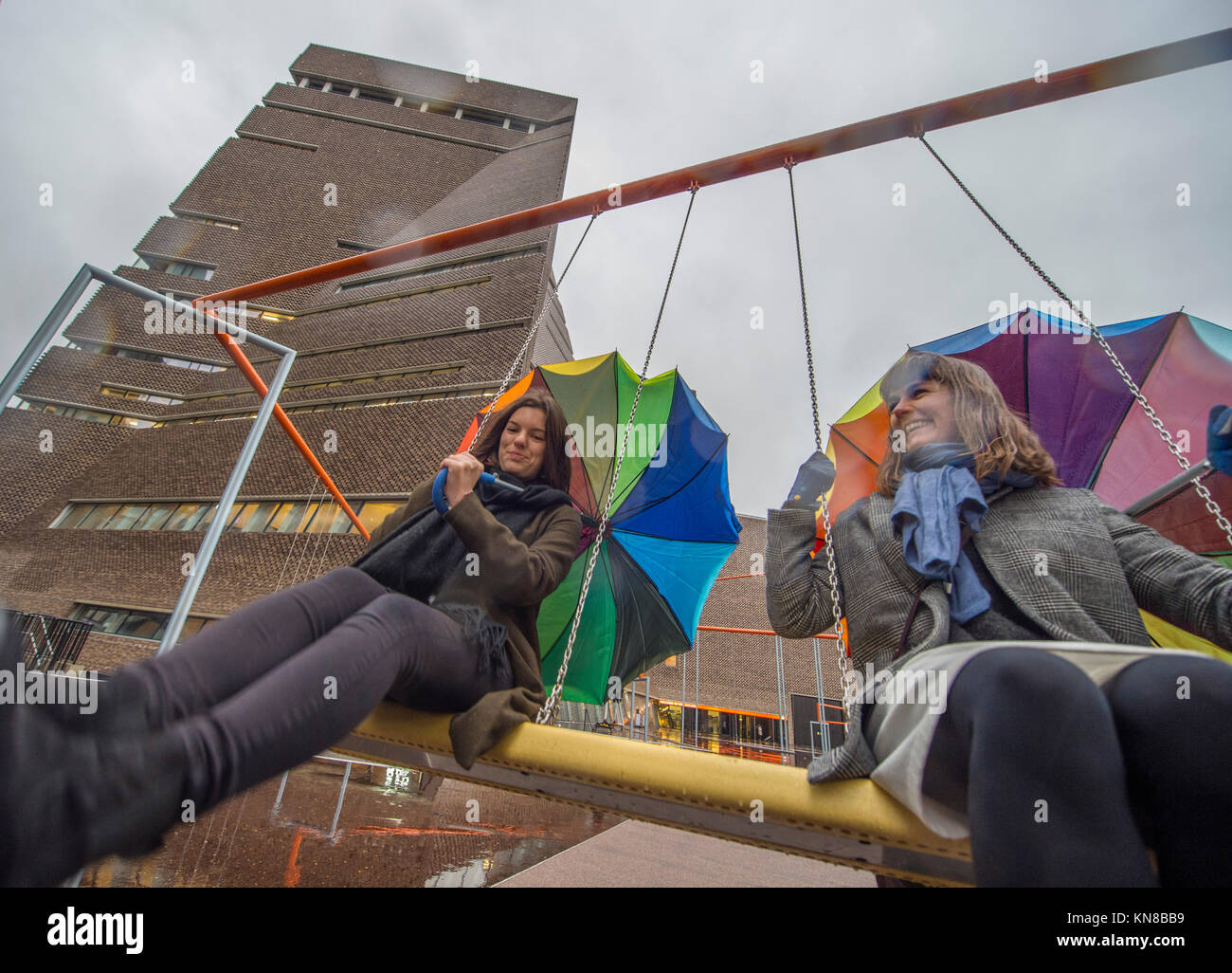 Tate Modern, London, UK. 11. Dezember, 2017. Elf schaukeln müssen außerhalb der Galerie Blavatnik Gebäude installiert wurde, als Teil einer groß angelegten interaktive Installation von Dänischen kollektiv SUPERFLEX. Eins, Zwei, Drei! Ist die erste Hyundai Kommission über die Turbine Hall zu erweitern und in die Landschaft draußen. Die großen Installation verfügt über elf 3 Sitz schwingt vor dem Hintergrund der legendären Tate Modern Gebäude mit Mitgliedern der lokalen Gemeinschaft genießen die Schaukeln für die erste Zeit im strömenden Regen. Credit: Malcolm Park/Alamy Leben Nachrichten. Stockfoto Tate Modern, London, UK. 11. Dezember, 2017. Elf schaukeln müssen außerhalb der Galerie Blavatnik Gebäude installiert wurde, als Teil einer groß angelegten interaktive Installation von Dänischen kollektiv SUPERFLEX. Eins, Zwei, Drei! Ist die erste Hyundai Kommission über die Turbine Hall zu erweitern und in die Landschaft draußen. Die großen Installation verfügt über elf 3 Sitz schwingt vor dem Hintergrund der legendären Tate Modern Gebäude mit Mitgliedern der lokalen Gemeinschaft genießen die Schaukeln für die erste Zeit im strömenden Regen. Credit: Malcolm Park/Alamy Leben Nachrichten. Stockfoto