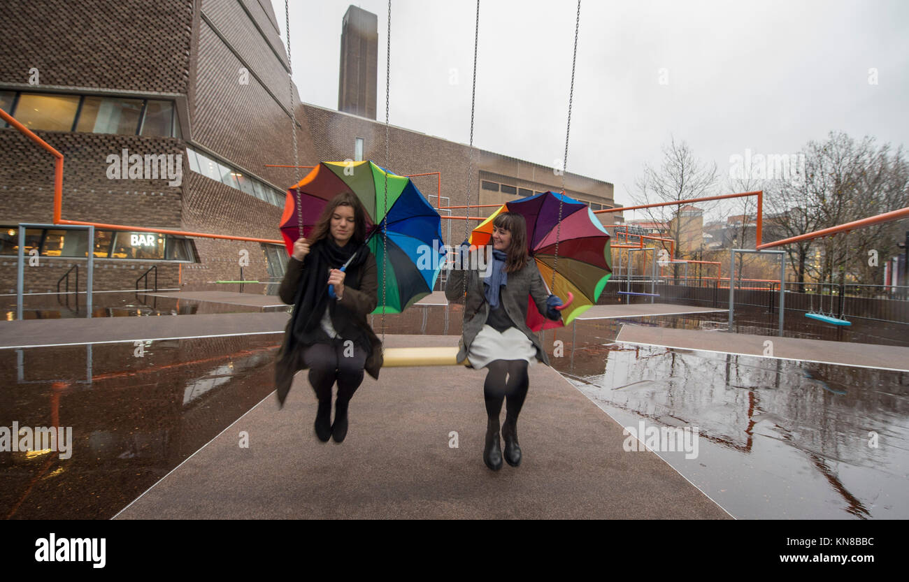 Tate Modern, London, UK. 11. Dezember, 2017. Elf schaukeln müssen außerhalb der Galerie Blavatnik Gebäude installiert wurde, als Teil einer groß angelegten interaktive Installation von Dänischen kollektiv SUPERFLEX. Eins, Zwei, Drei! Ist die erste Hyundai Kommission über die Turbine Hall zu erweitern und in die Landschaft draußen. Die großen Installation verfügt über elf 3 Sitz schwingt vor dem Hintergrund der legendären Tate Modern Gebäude mit Mitgliedern der lokalen Gemeinschaft genießen die Schaukeln für die erste Zeit im strömenden Regen. Credit: Malcolm Park/Alamy Leben Nachrichten. Stockfoto