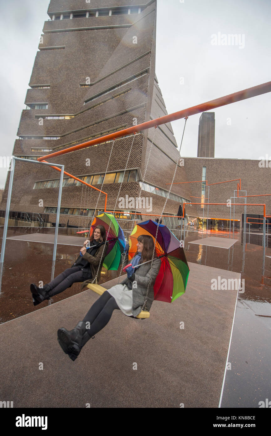 Tate Modern, London, UK. 11. Dezember, 2017. Elf schaukeln müssen außerhalb der Galerie Blavatnik Gebäude installiert wurde, als Teil einer groß angelegten interaktive Installation von Dänischen kollektiv SUPERFLEX. Eins, Zwei, Drei! Ist die erste Hyundai Kommission über die Turbine Hall zu erweitern und in die Landschaft draußen. Die großen Installation verfügt über elf 3 Sitz schwingt vor dem Hintergrund der legendären Tate Modern Gebäude mit Mitgliedern der lokalen Gemeinschaft genießen die Schaukeln für die erste Zeit im strömenden Regen. Credit: Malcolm Park/Alamy Leben Nachrichten. Stockfoto