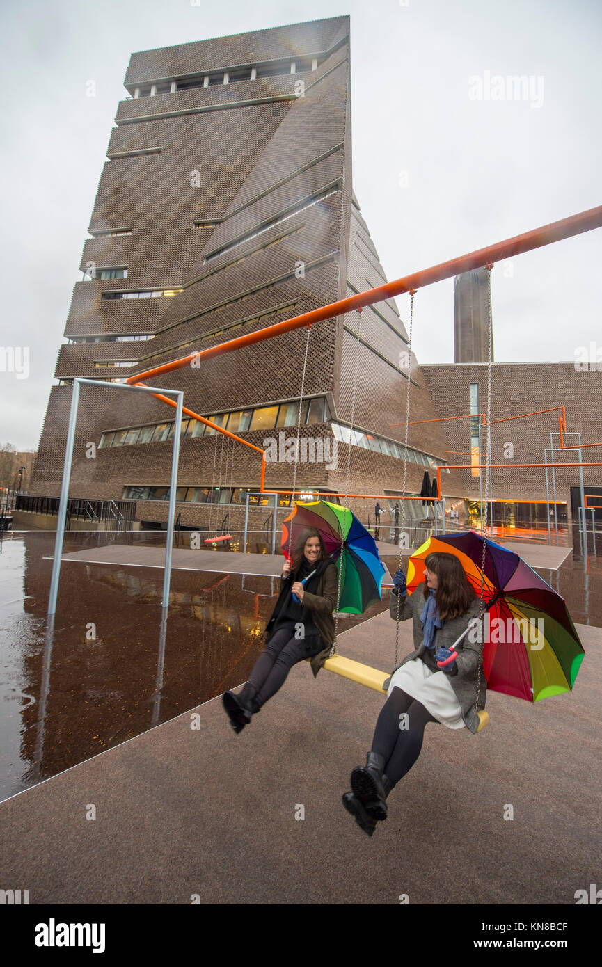 Tate Modern, London, UK. 11. Dezember, 2017. Elf schaukeln müssen außerhalb der Galerie Blavatnik Gebäude installiert wurde, als Teil einer groß angelegten interaktive Installation von Dänischen kollektiv SUPERFLEX. Eins, Zwei, Drei! Ist die erste Hyundai Kommission über die Turbine Hall zu erweitern und in die Landschaft draußen. Die großen Installation verfügt über elf 3 Sitz schwingt vor dem Hintergrund der legendären Tate Modern Gebäude mit Mitgliedern der lokalen Gemeinschaft genießen die Schaukeln für die erste Zeit im strömenden Regen. Credit: Malcolm Park/Alamy Leben Nachrichten. Stockfoto