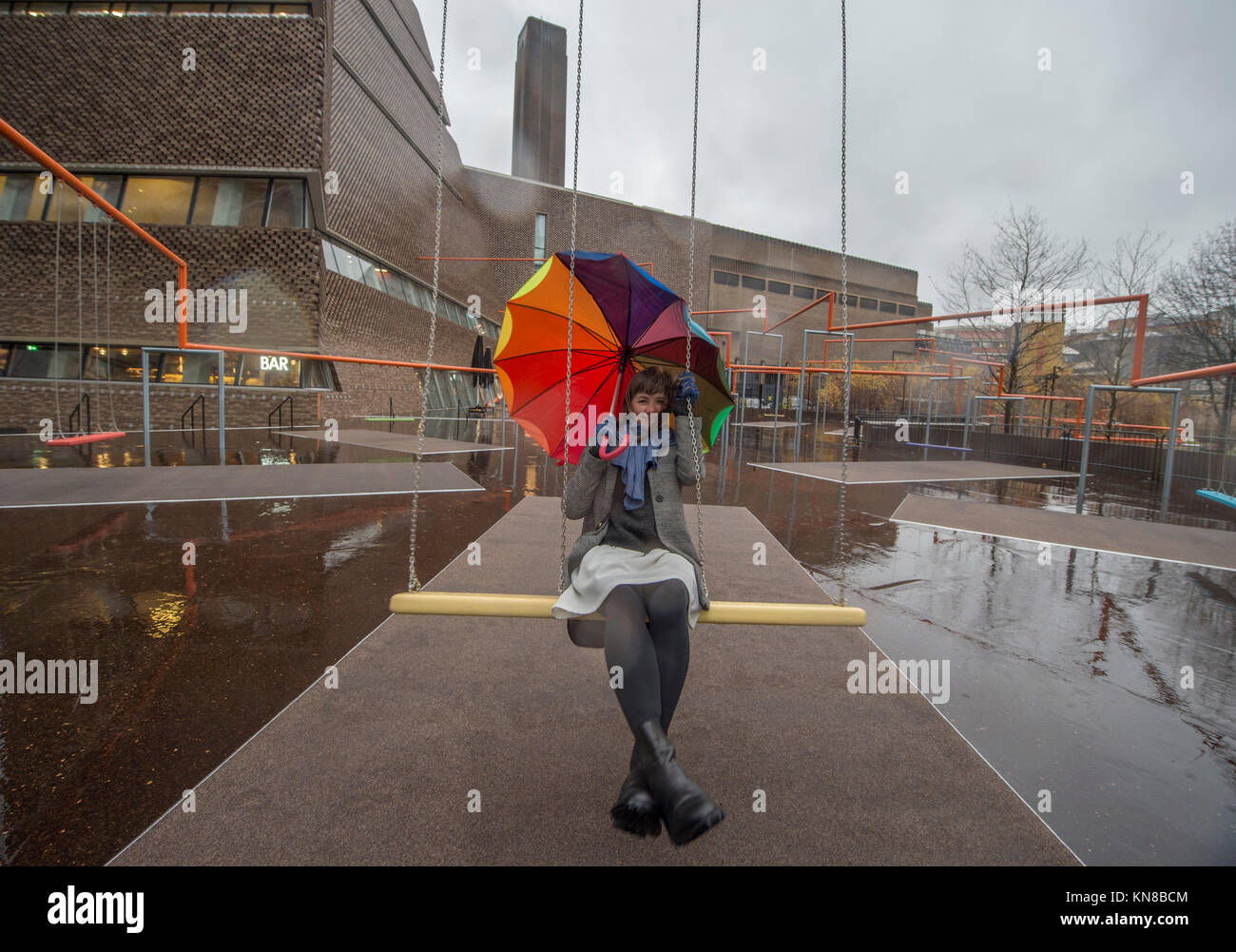 Tate Modern, London, UK. 11. Dezember, 2017. Elf schaukeln müssen außerhalb der Galerie Blavatnik Gebäude installiert wurde, als Teil einer groß angelegten interaktive Installation von Dänischen kollektiv SUPERFLEX. Eins, Zwei, Drei! Ist die erste Hyundai Kommission über die Turbine Hall zu erweitern und in die Landschaft draußen. Die großen Installation verfügt über elf 3 Sitz schwingt vor dem Hintergrund der legendären Tate Modern Gebäude mit Mitgliedern der lokalen Gemeinschaft genießen die Schaukeln für die erste Zeit im strömenden Regen. Credit: Malcolm Park/Alamy Leben Nachrichten. Stockfoto