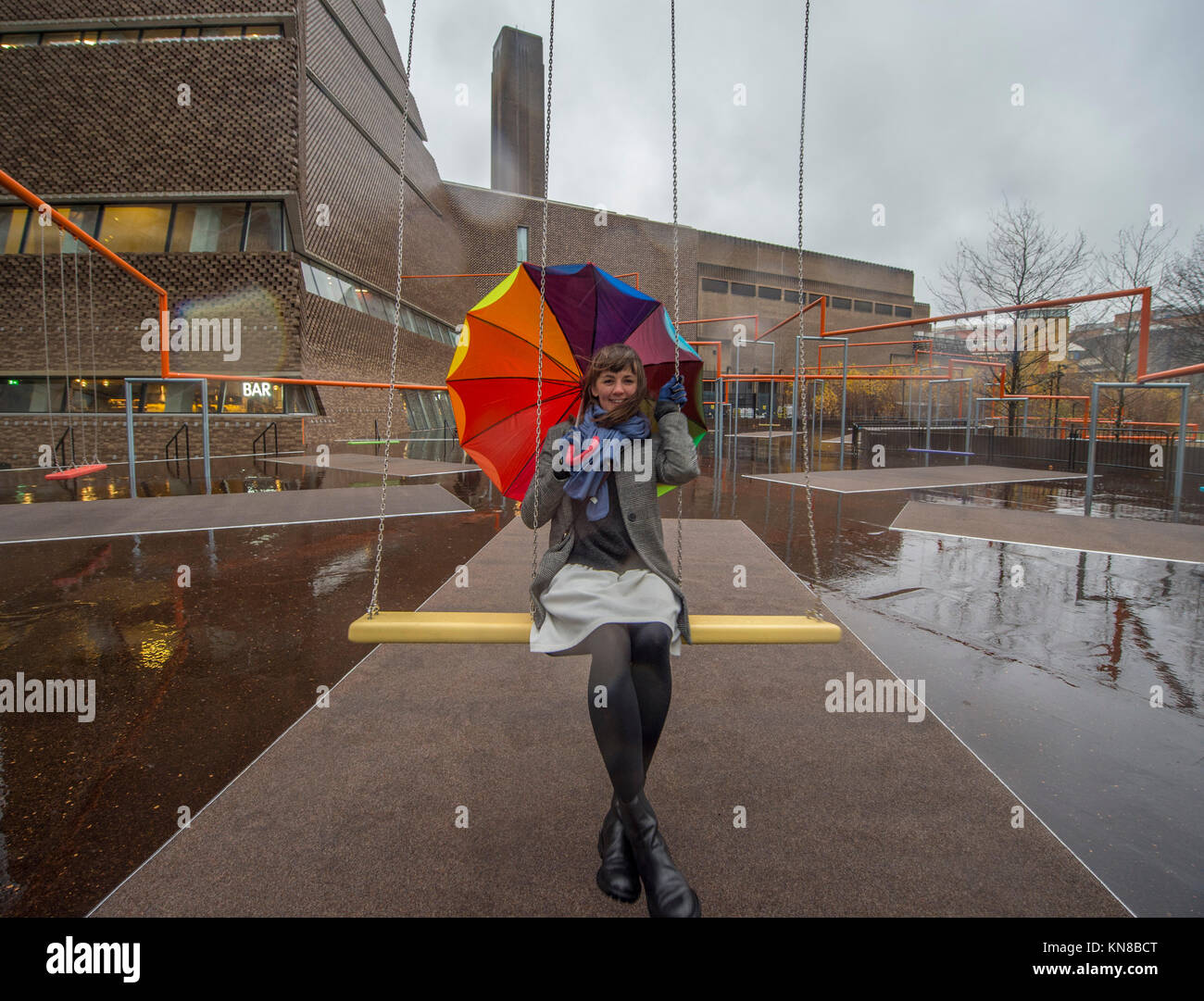 Tate Modern, London, UK. 11. Dezember, 2017. Elf schaukeln müssen außerhalb der Galerie Blavatnik Gebäude installiert wurde, als Teil einer groß angelegten interaktive Installation von Dänischen kollektiv SUPERFLEX. Eins, Zwei, Drei! Ist die erste Hyundai Kommission über die Turbine Hall zu erweitern und in die Landschaft draußen. Die großen Installation verfügt über elf 3 Sitz schwingt vor dem Hintergrund der legendären Tate Modern Gebäude mit Mitgliedern der lokalen Gemeinschaft genießen die Schaukeln für die erste Zeit im strömenden Regen. Credit: Malcolm Park/Alamy Leben Nachrichten. Stockfoto