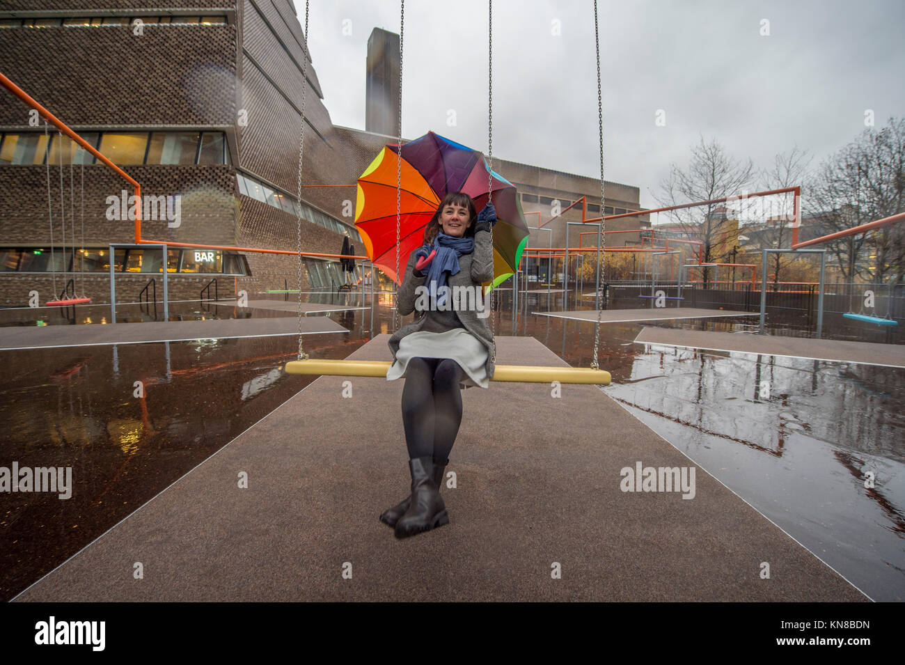 Tate Modern, London, UK. 11. Dezember, 2017. Elf schaukeln müssen außerhalb der Galerie Blavatnik Gebäude installiert wurde, als Teil einer groß angelegten interaktive Installation von Dänischen kollektiv SUPERFLEX. Eins, Zwei, Drei! Ist die erste Hyundai Kommission über die Turbine Hall zu erweitern und in die Landschaft draußen. Die großen Installation verfügt über elf 3 Sitz schwingt vor dem Hintergrund der legendären Tate Modern Gebäude mit Mitgliedern der lokalen Gemeinschaft genießen die Schaukeln für die erste Zeit im strömenden Regen. Credit: Malcolm Park/Alamy Leben Nachrichten. Stockfoto