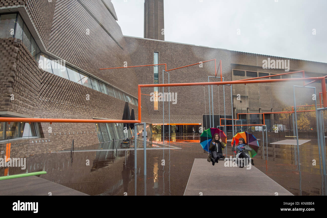 Tate Modern, London, UK. 11. Dezember, 2017. Elf schaukeln müssen außerhalb der Galerie Blavatnik Gebäude installiert wurde, als Teil einer groß angelegten interaktive Installation von Dänischen kollektiv SUPERFLEX. Eins, Zwei, Drei! Ist die erste Hyundai Kommission über die Turbine Hall zu erweitern und in die Landschaft draußen. Die großen Installation verfügt über elf 3 Sitz schwingt vor dem Hintergrund der legendären Tate Modern Gebäude mit Mitgliedern der lokalen Gemeinschaft genießen die Schaukeln für die erste Zeit im strömenden Regen. Credit: Malcolm Park/Alamy Leben Nachrichten. Stockfoto