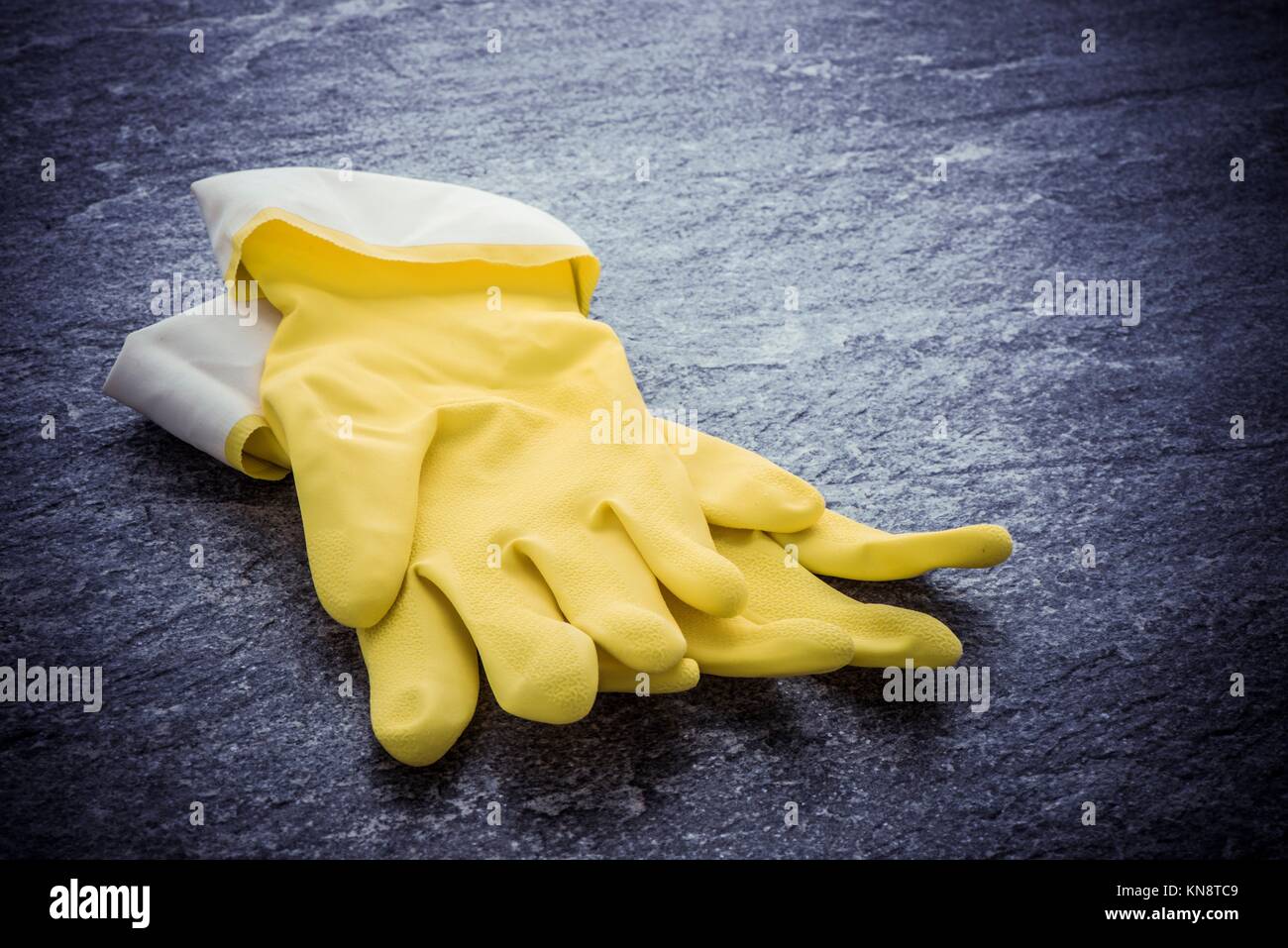 Gelbe Gummihandschuhe liegen auf Stein Oberfläche. Image an, das Konzept der Reinigung, Hausarbeit und Schutzkleidung. Stockfoto