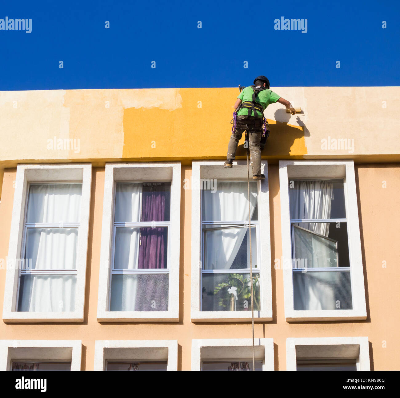 Workman paintin Appartementhaus in Spanien Stockfoto