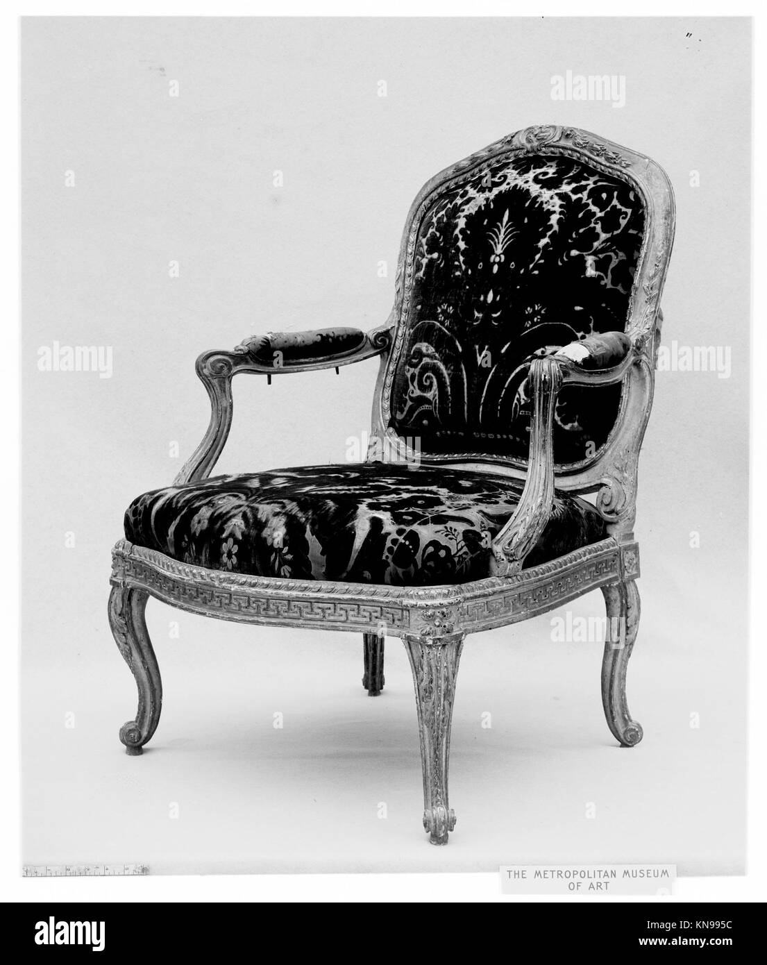 Dieser Sessel von Jean-Jacques Pothier (um 1765) ist aus geschnitztem und vergoldetem Buchenholz mit geschliffener Samtpolsterung gefertigt und zeigt die französische Möbelhandwerkskunst des 18. Jahrhunderts. Stockfoto