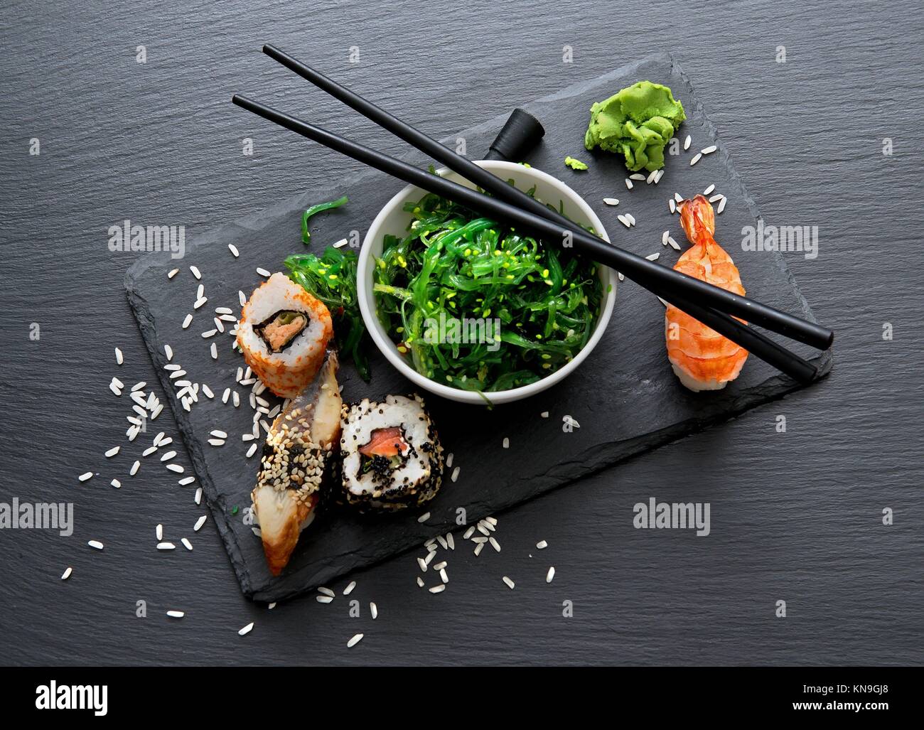 Sushi und Algensalat auf schiefer Tisch. Stockfoto