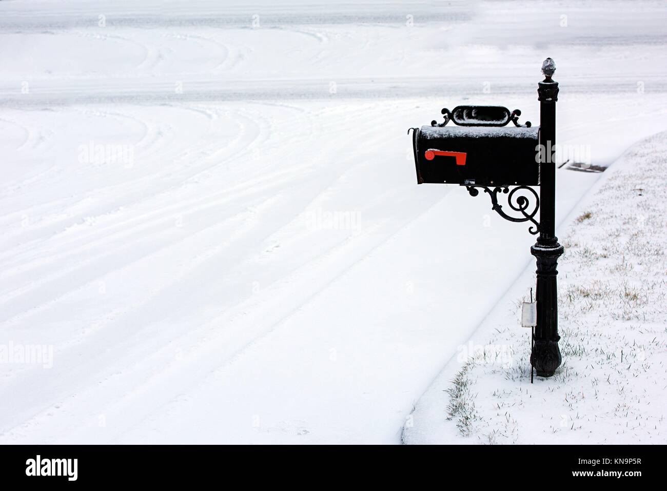 Eine schwarze Mailbox bedeckt mit frischen weißen Schnee. Stockfoto