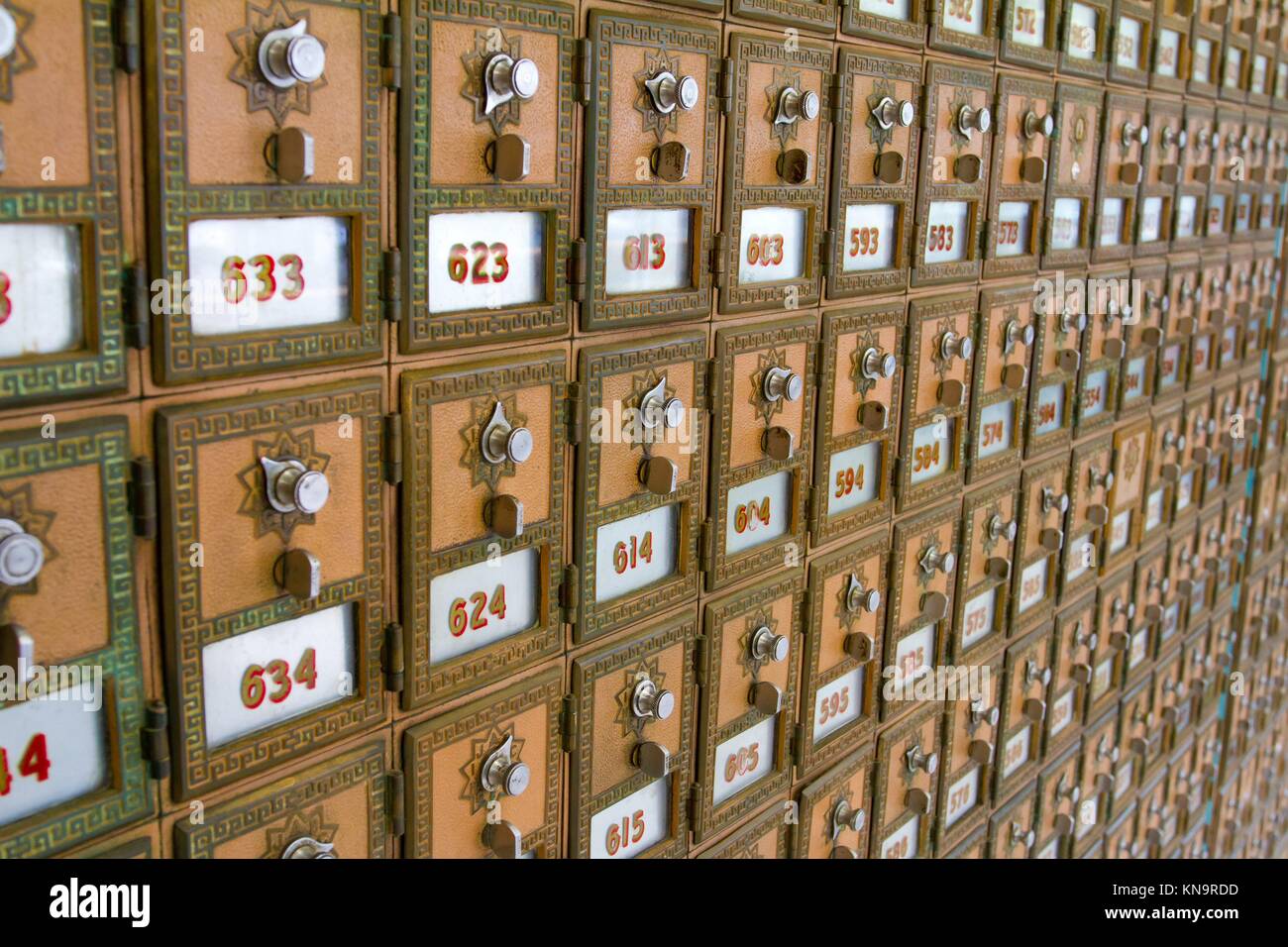 Dieses Foto zeigt viele Postfächer bei der Post. Die Briefkästen sind in Zeilen und Spalten für Organisation aufgereiht. Stockfoto
