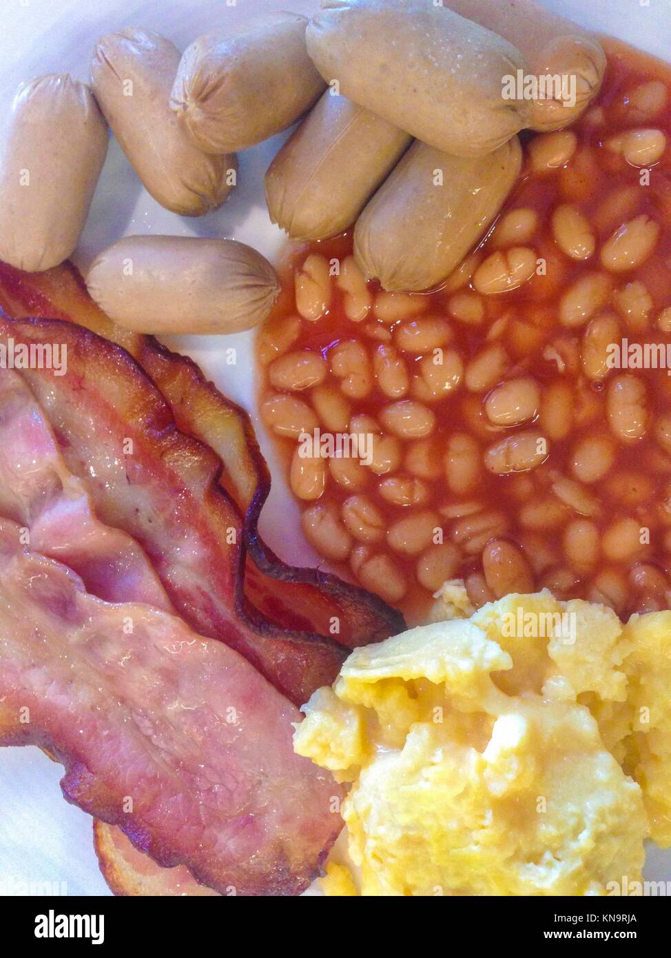 Nahrhaftes englisches Frühstück auf einem Teller mit Brot, Orangensaft und Kaffee Tasse. Stockfoto