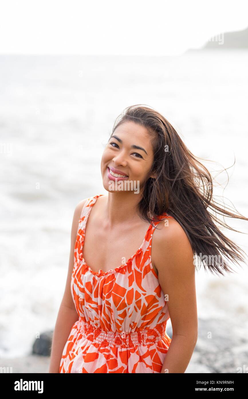 Lifestyle Porträt einer attraktiven Hawaiian Frau trägt eine Blumenkleid  Kahana Bay auf Oahu Hawaii Stockfotografie - Alamy
