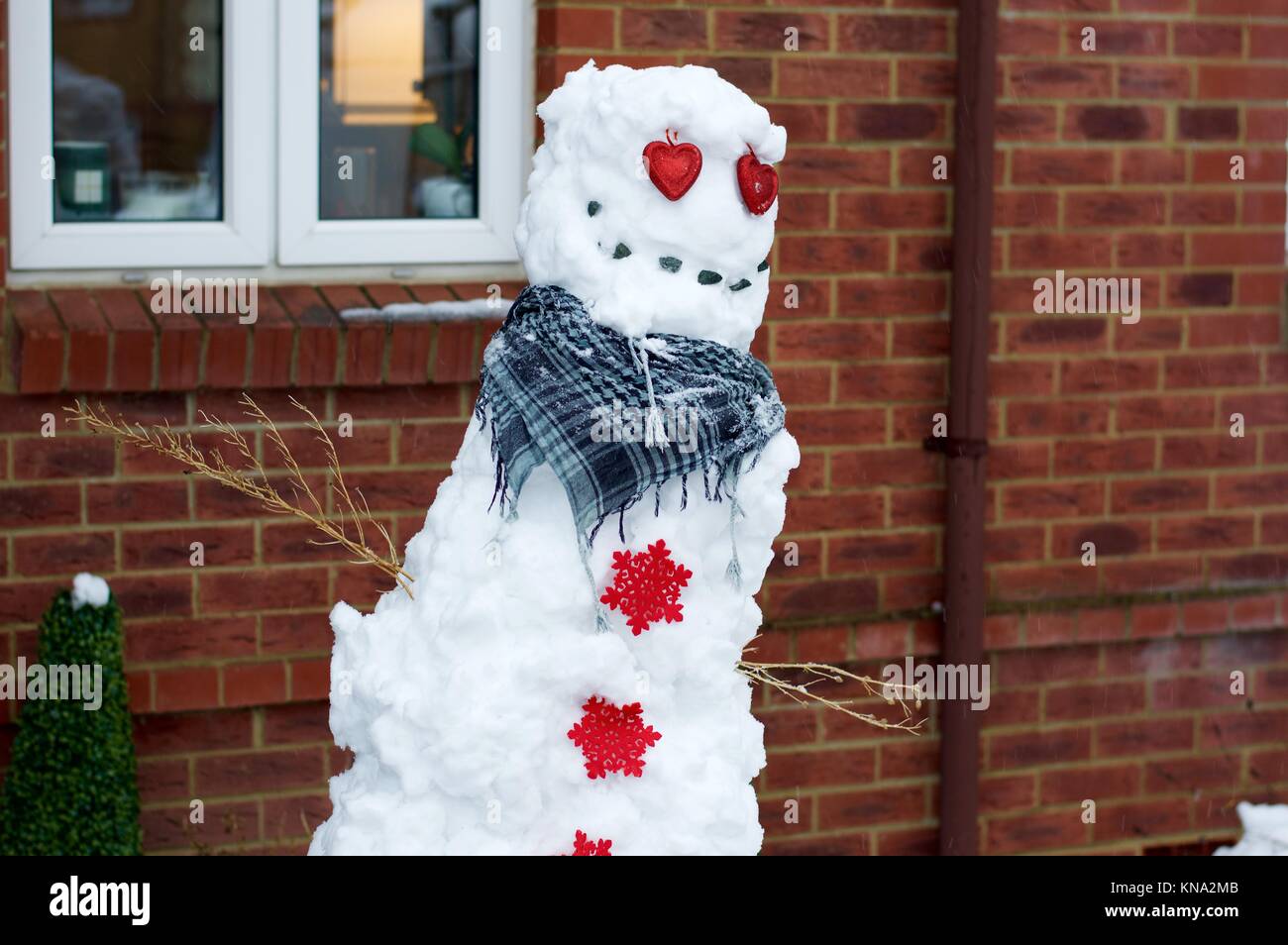 Ziemlich schlecht aussehende Schneemann in Vorgarten in Hemel Hempstead, Hertfordshire, Großbritannien Stockfoto