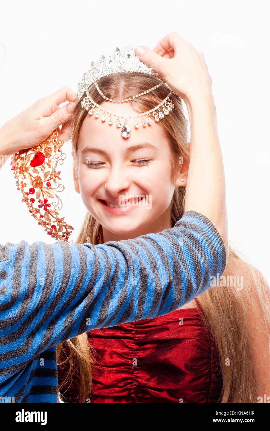 Mädchen mit blonden Haaren im roten Kleid gerade eine Krone auf dem Kopf. Stockfoto