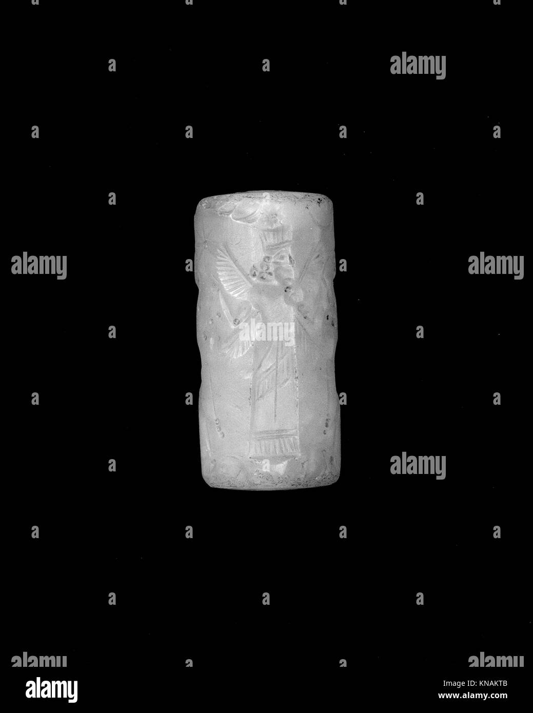 Dieses Zylindersiegel und der Eindruck zeigen Stiermänner, die eine Gottheit mit einem heiligen Baum flankieren, und eine geflügelte Gottheit mit gehörnten Tierköpfen, die mythologische Themen illustrieren. Stockfoto