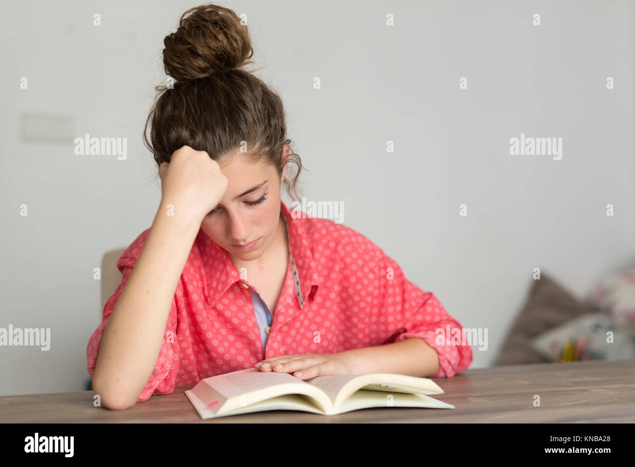 Teen Frau liest ein Buch. Horizontal gedreht mit Tageslicht durch ein Fenster betreten. Stockfoto