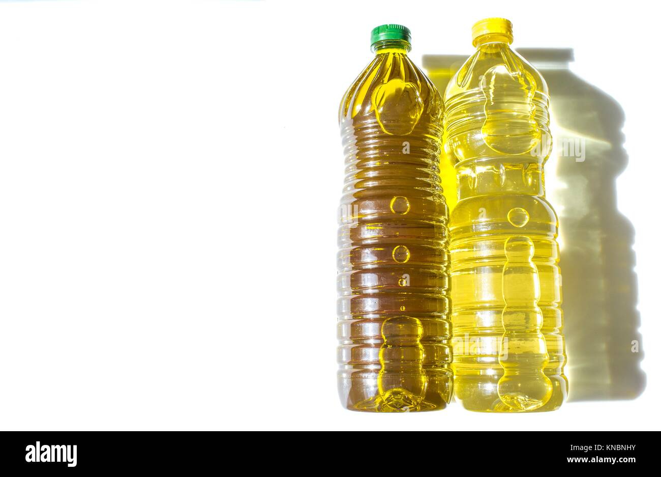Olivenöl und Sonnenblumenöl in PET-Flaschen. Über weiß isoliert. Stockfoto