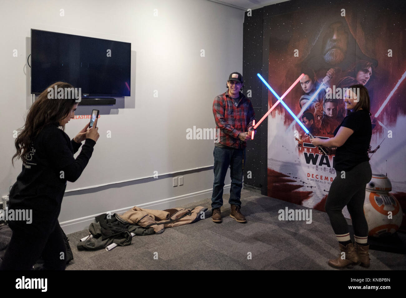 Star Wars Fans posieren für Fotos mit lichtschwertern vor einem Plakat der Star Wars Der letzte Jedi, Pop's Film-up Stores in der Innenstadt von Toronto, Kanada. Stockfoto
