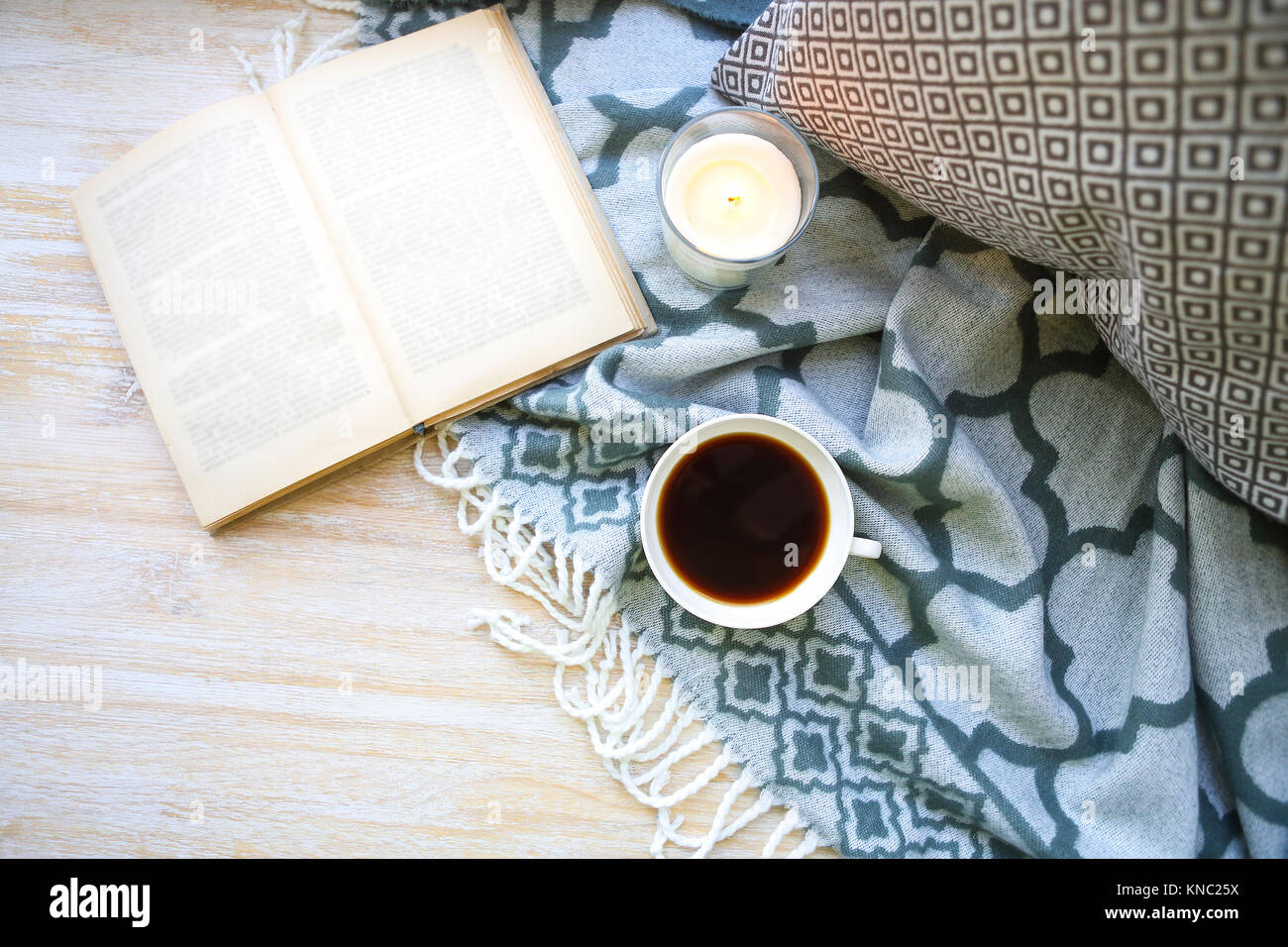 Tasse Kaffee, Kerze und Buch auf dem Holzboden Stockfoto