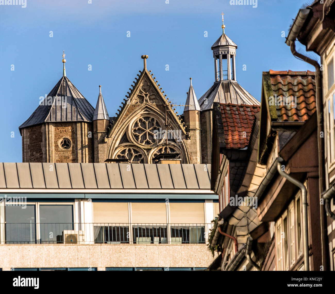 Die alte Fassade der Kathedrale hinter einem neuen Kaufhaus in Braunschweig, Deutschland mit Häuser der Altstadt vor. Stockfoto