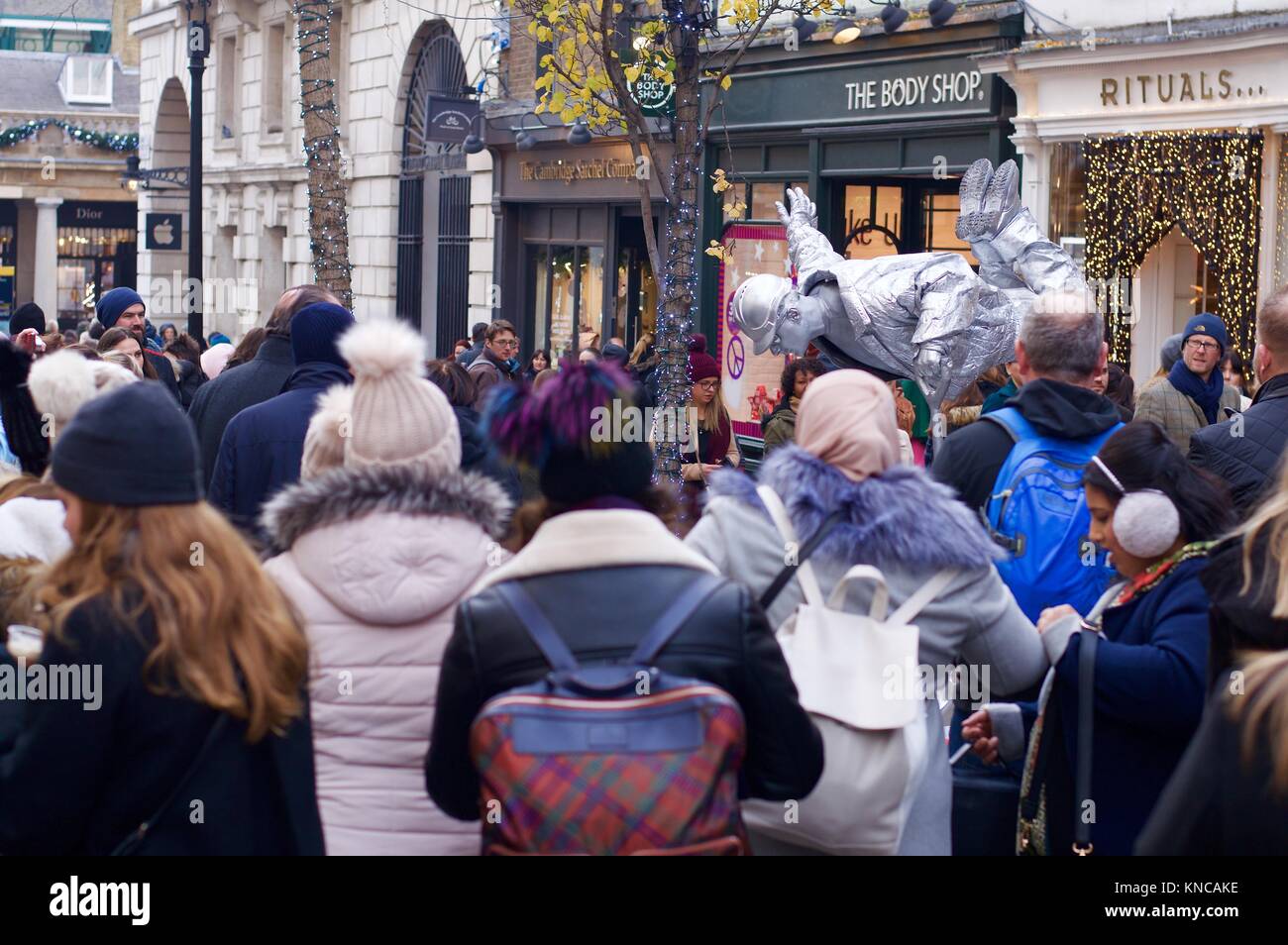 Floating Silver Street Performer in Covent Garden vor Weihnachten mit Käufern vorbei und beobachten, London, UK Stockfoto