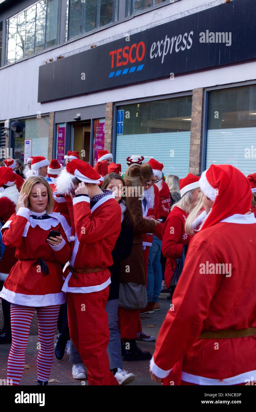Flash Mob verkleidet als Weihnachtsmann zu Fuß durch London und tranken und waren fröhlich für Santacon 2017 im Norden von London, King's Cross Bereich Stockfoto