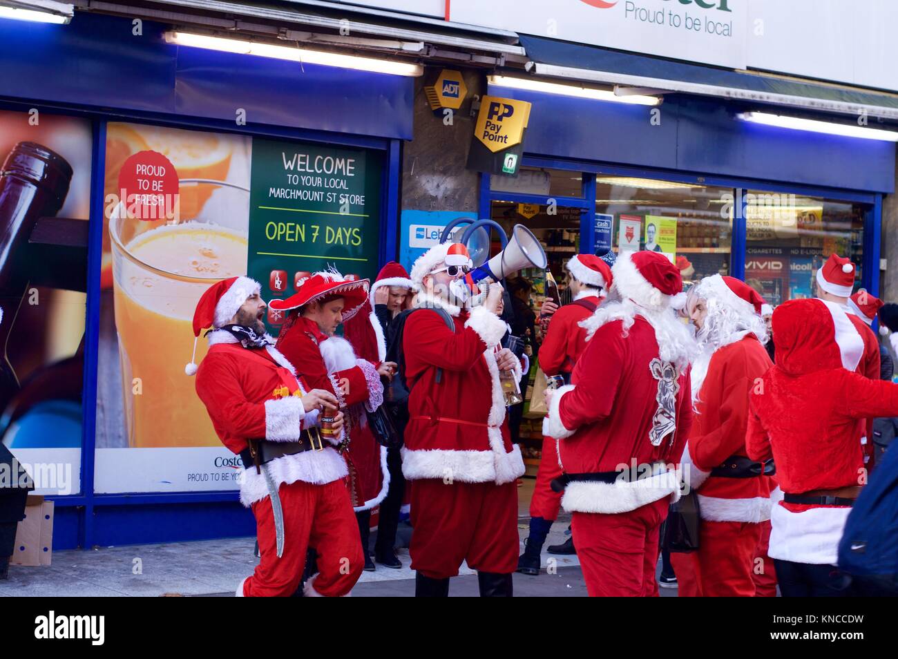 Flash Mob verkleidet als Weihnachtsmann zu Fuß durch London und tranken und waren fröhlich für Santacon 2017 im Norden von London, King's Cross Bereich Stockfoto