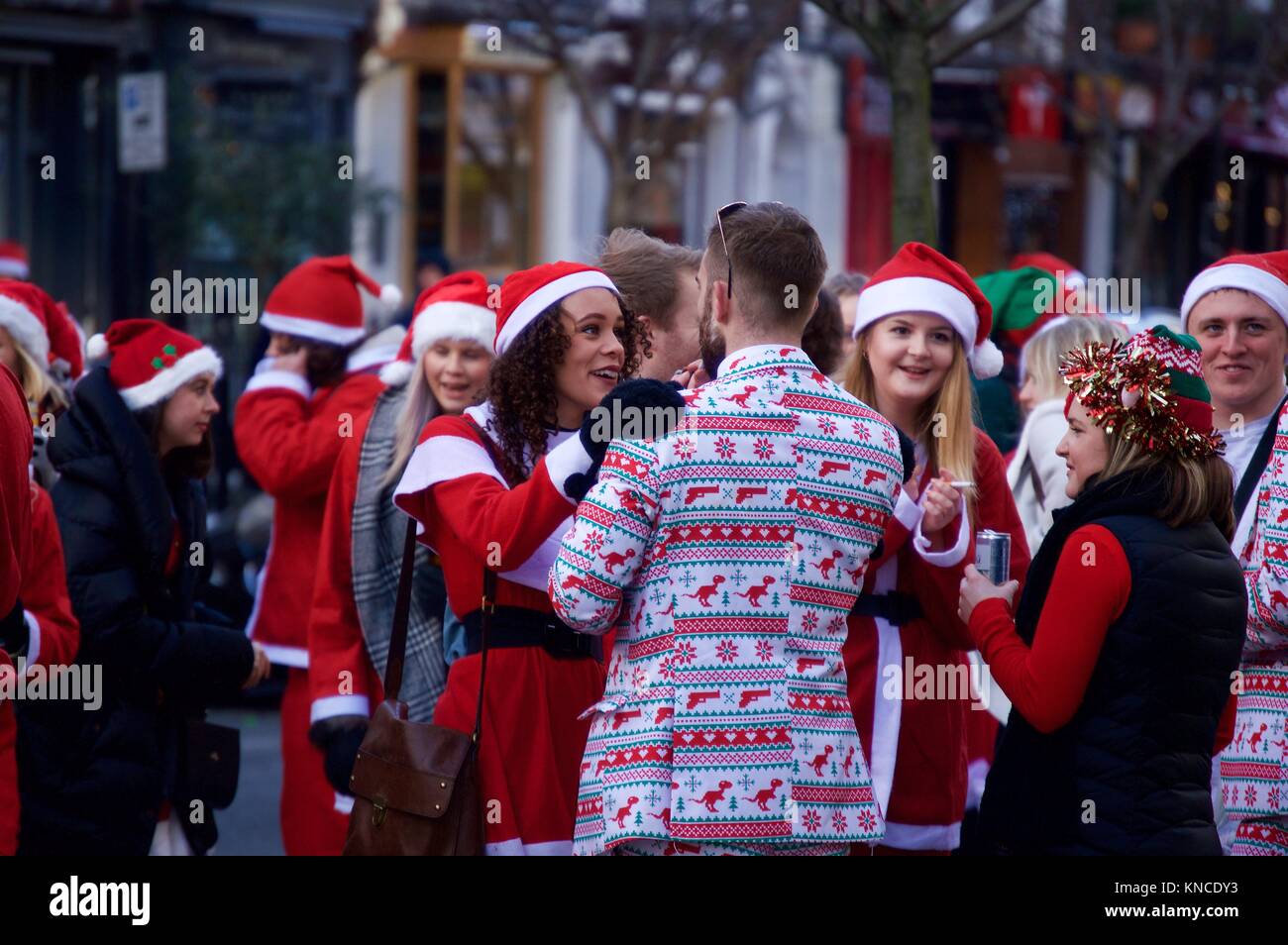 Flash Mob verkleidet als Weihnachtsmann zu Fuß durch London und tranken und waren fröhlich für Santacon 2017 im Norden von London, King's Cross Bereich Stockfoto