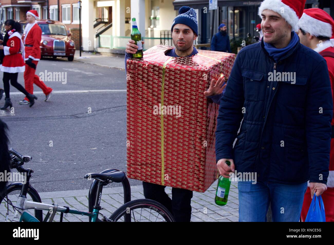 Flash Mob verkleidet als Weihnachtsmann zu Fuß durch London und tranken und waren fröhlich für Santacon 2017 im Norden von London, King's Cross Bereich Stockfoto