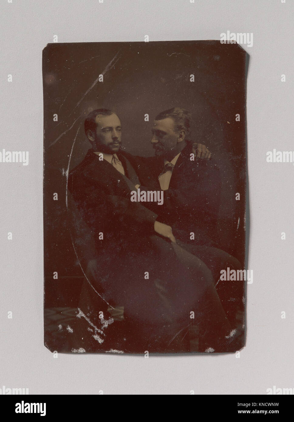 Diese Abbildung zeigt zwei Männer, die sitzen, einer auf dem Schoß mit Händen in suggestiven Positionen, die intime Interaktion und expressive Haltungen im historischen Kontext widerspiegeln. Stockfoto