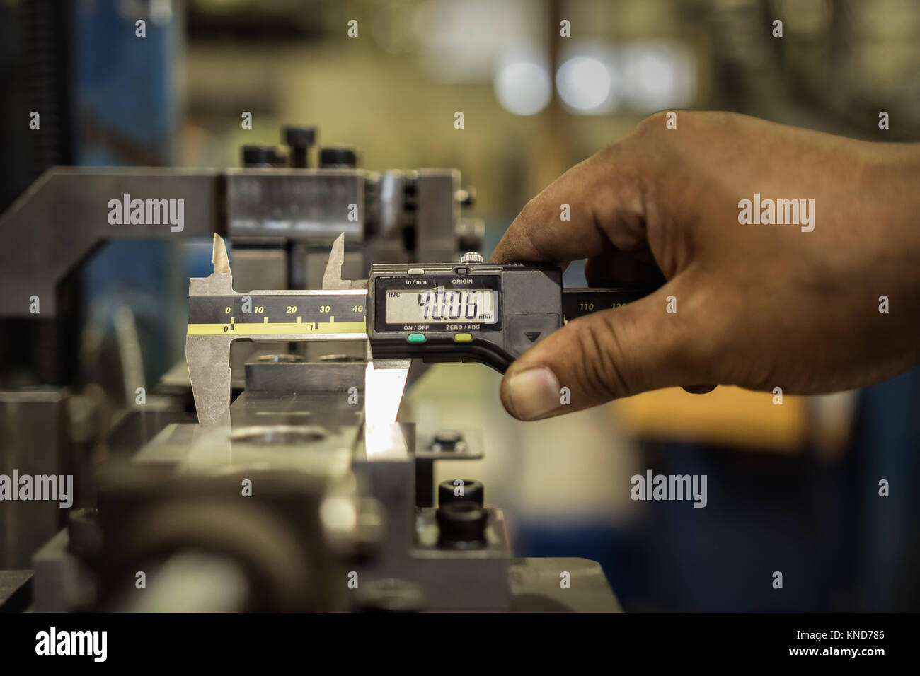 Factory mann Arbeitnehmer messen Stahl Detail mit Digitaler Messschieber in Werkstatt Stockfoto